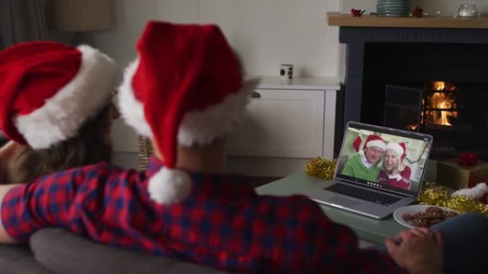 圣诞节时，白人夫妇与祖父母在笔记本电脑上进行视频通话