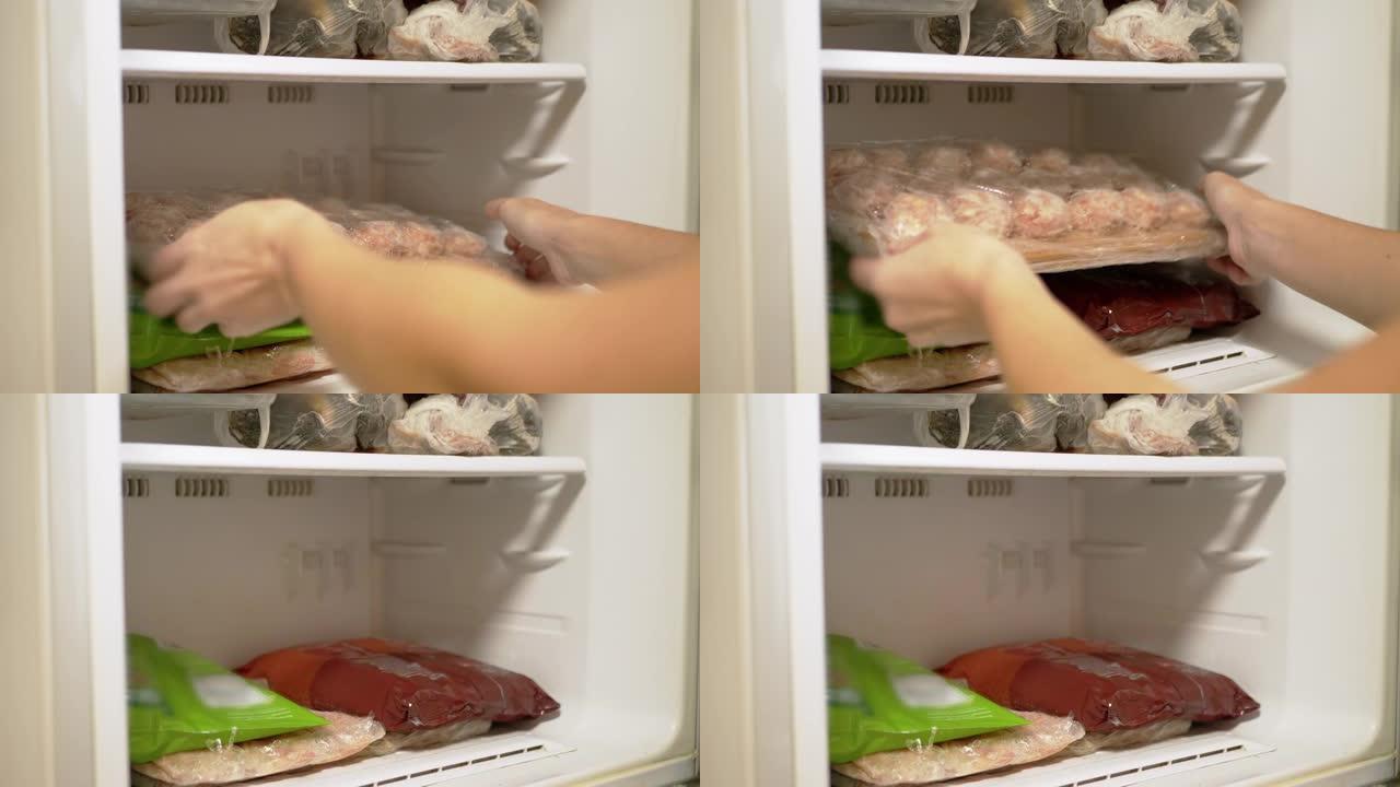 女性的手从冰柜中取出冷冻的半成品肉制品。4K
