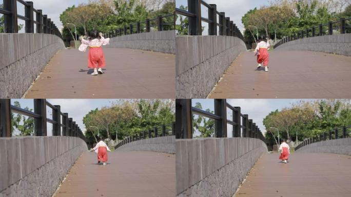 大晴天，穿着日本传统服装的可爱亚洲小女孩在公园的桥上嬉戏，蹒跚前行。
