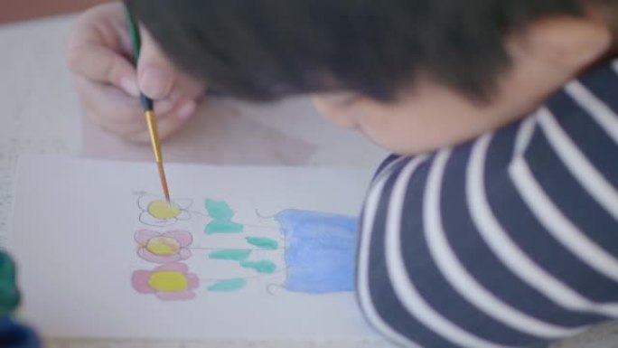 亚洲男孩在家画水彩花