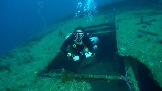 女性技术侧在沉船上安装水肺潜水员