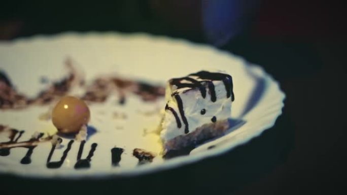 人在盘子里吃完浆果和巧克力蛋糕
