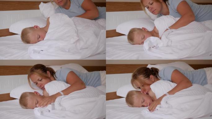 一位母亲早上在床上亲吻熟睡的儿子的特写镜头。