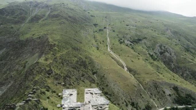 奇妙的鸟瞰图青山山和山顶上的古石建筑。行动。建在山峰上的旧石质白色废弃塔。