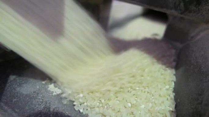 经过加工的大米在现代农业工厂的金属槽中快速流过