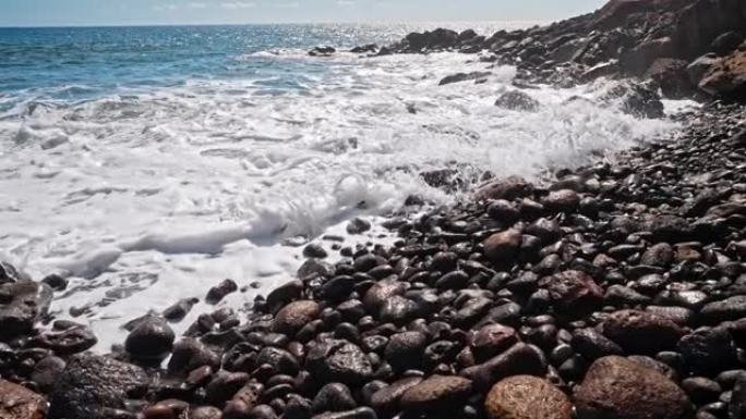 大西洋海景、水面、波纹、圆石滩上的小浪。普遍自然，度假胜地，暑假自然背景。