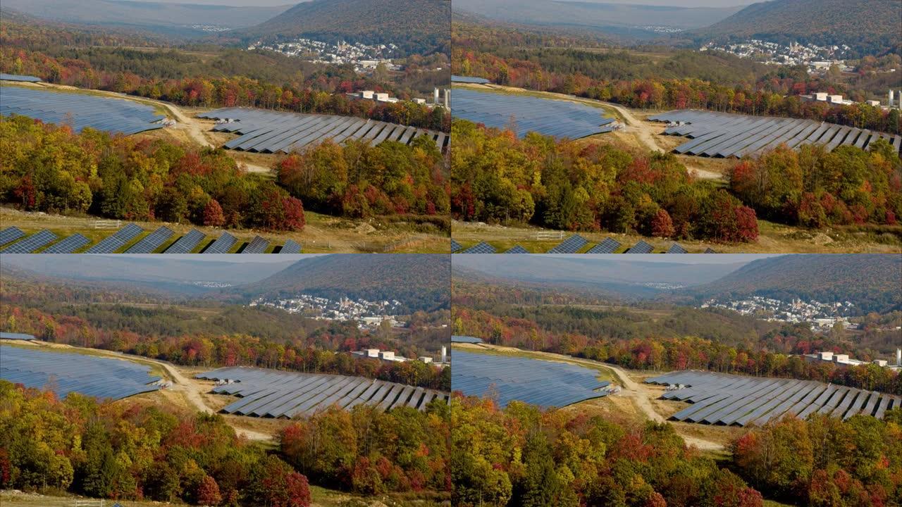 宾夕法尼亚州阿巴拉契亚山脉的大型太阳能农场，在一个五颜六色的秋天。带有转发摄像机运动的航空视频。