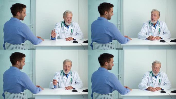 成熟的男性成年医生采访患病的男性患者，并在医疗办公室的餐桌旁写处方。