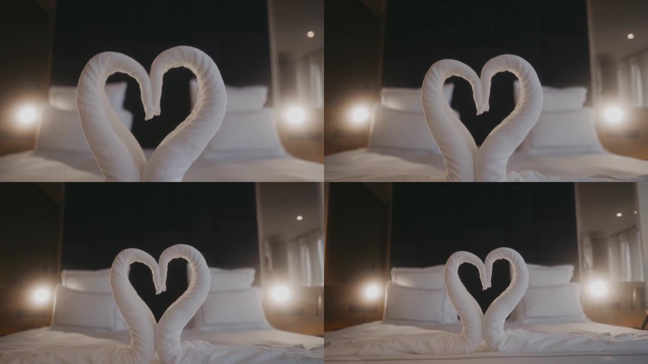 毛巾在浪漫的酒店房间床上折叠成天鹅