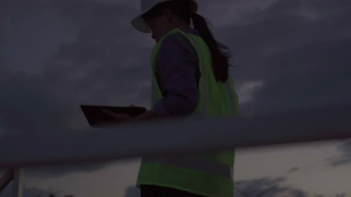女工程师夜间评估风力涡轮机