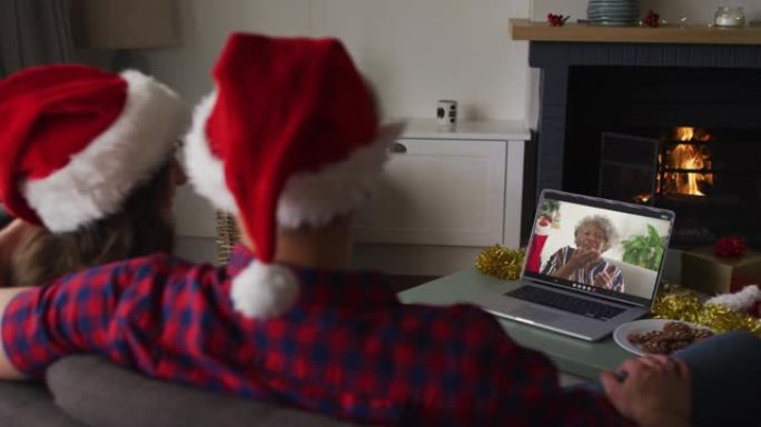 圣诞节时，白人夫妇在笔记本电脑上与资深女性朋友进行视频通话