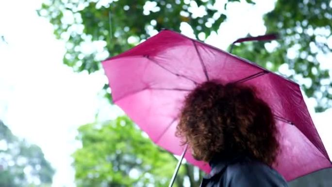 非洲妇女在雨天在外面打开雨伞