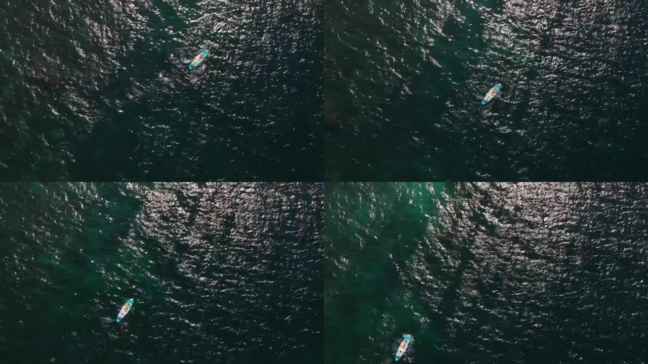 人们在公海的蓝色皮划艇上，从高处看