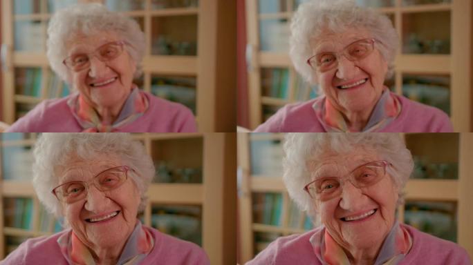 一位快乐的老年妇女的肖像，满头白发看着相机，洁白的牙齿微笑。