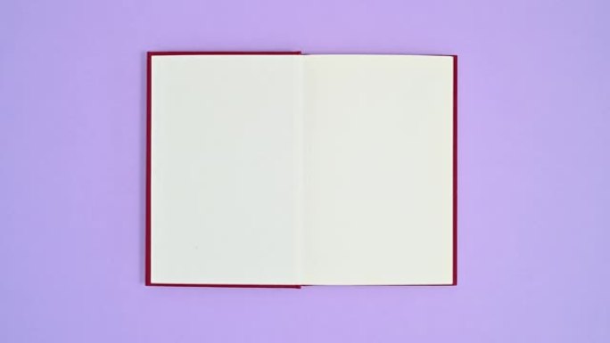深红色精装书以紫色主题出现并打开。停止运动平铺