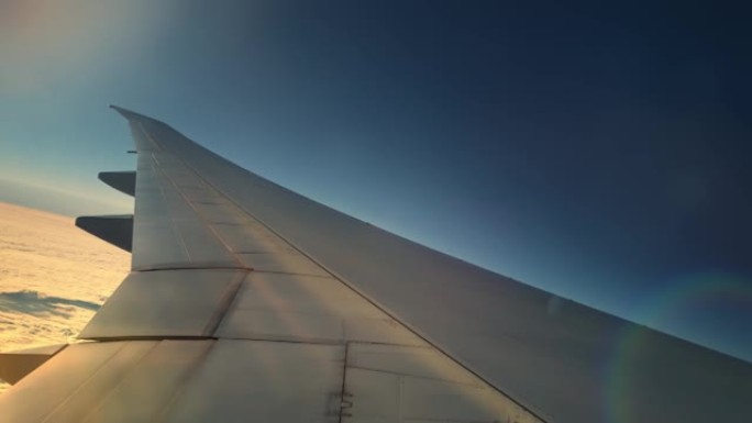 早上从窗户拍摄的飞机机翼飞过云层