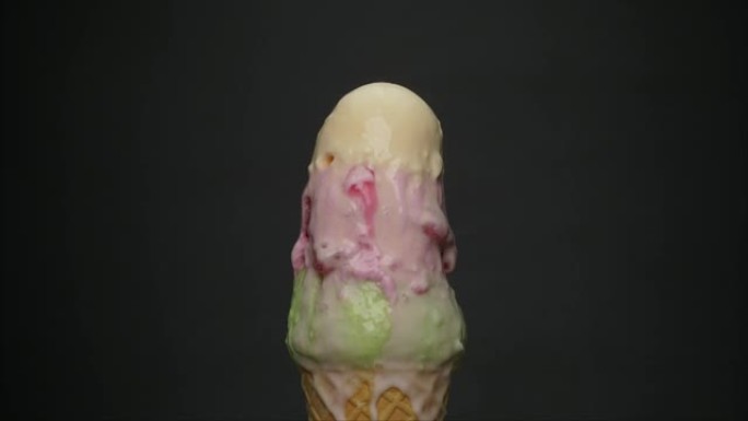 时间流逝，三种口味的冰淇淋在圆锥体上融化。