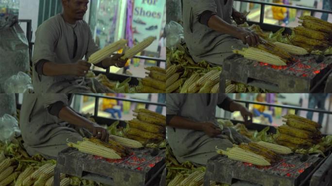 阿拉伯男子正在准备玉米并在街上出售