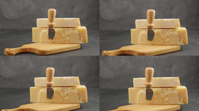 帕尔马干酪。两种类型的帕尔马干酪。帕尔马干酪刀。帕玛森奶酪躺在木板上。24个月和48个月