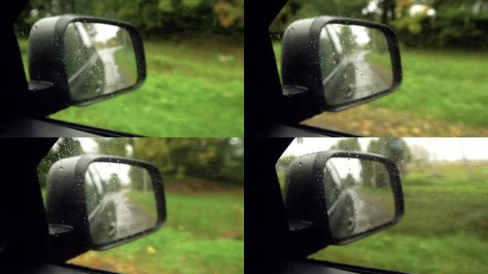 沿着乡村道路行驶的汽车后视镜中的反射。