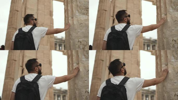 雅典卫城内的游客接触古代废墟寺庙的柱子