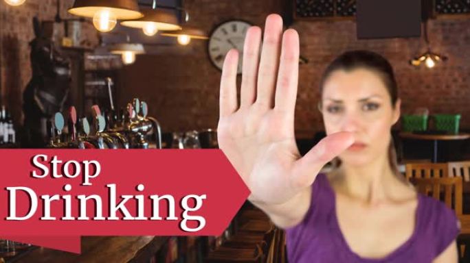 动画停止喝酒的文字与白人妇女作出停止手标志，在酒吧内部
