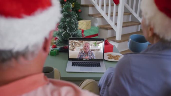 快乐的高加索高级夫妇在圣诞节与男性朋友进行视频通话