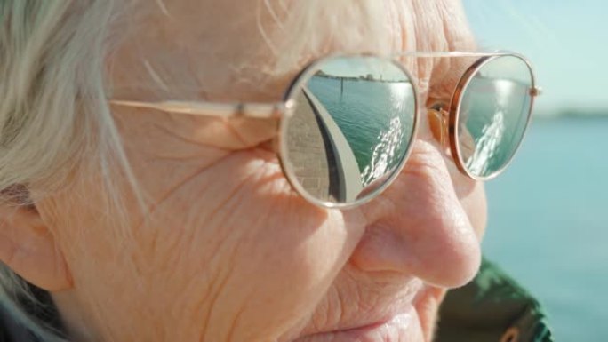 戴着墨镜的皱纹老妇人喜欢泻湖的天气