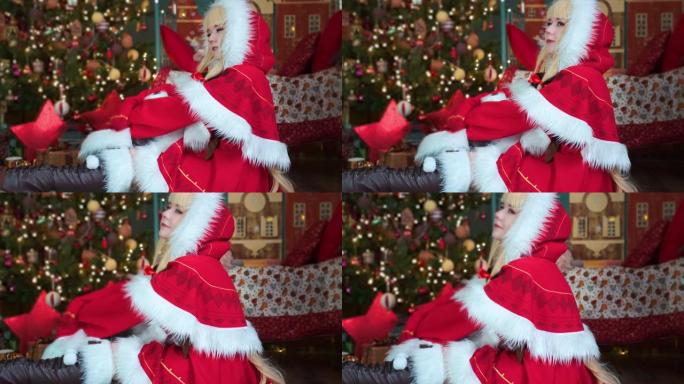 可爱的女孩角色扮演圣诞米库圣诞老人礼服与礼物。新年精灵。坐在地板上