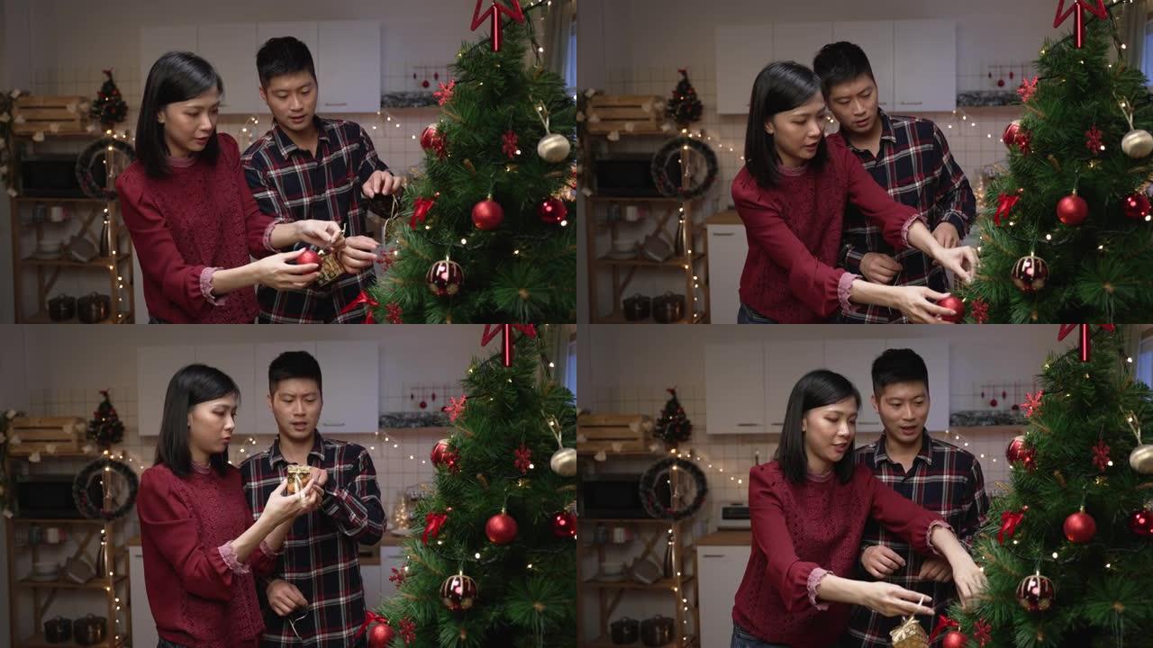 微笑的亚洲夫妇在一起享受装饰圣诞树的同时交换想法，为在家庆祝节日和新年做好准备