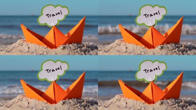 沙滩上的橙色纸船特写。阳光明媚的夏日，蓝色大海背景上的小船。坚持在船上插入文字旅行。概念旅游、度假、