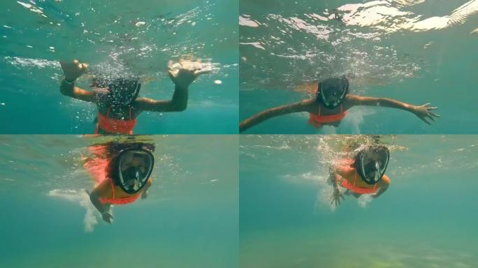 童女戴着全景面具在水下游泳。一个在水下浮潜的孩子。女孩漂浮在海面上