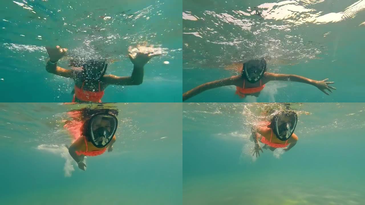 童女戴着全景面具在水下游泳。一个在水下浮潜的孩子。女孩漂浮在海面上