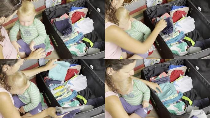 妈妈收拾衣服，整理行李，腿上放着婴儿