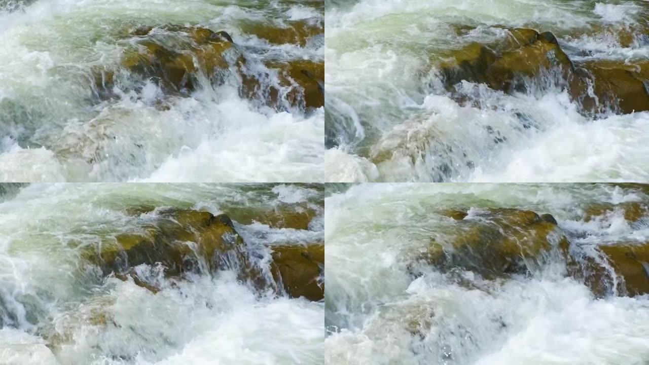 山河，清澈的绿松石水在湿石块之间的梯级中落下，白色泡沫浓厚
