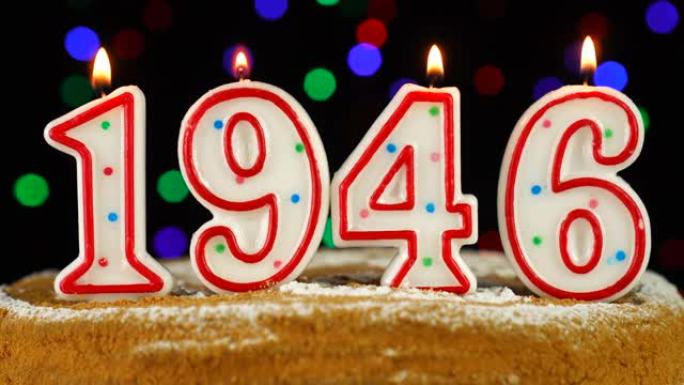 生日蛋糕与白色燃烧的蜡烛在数字1946的形式