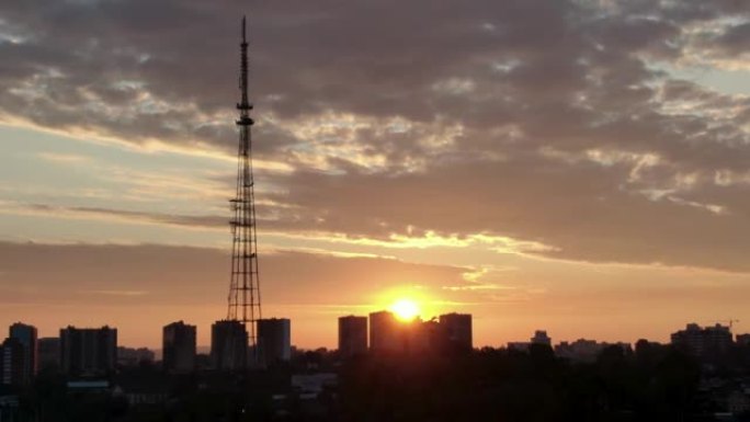 伊尔库茨克市上空的黎明。太阳从电视塔上空升起。燕子在旭日的背景下飞过。从无人机上射击。顶视图