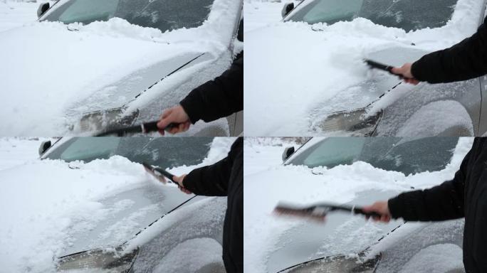 暴风雪暴风雪后，人从车窗上刷新鲜的雪。冬季寒冷天气车主的早晨常规困难。车窗清洁。冬季。白雪。车辆保养