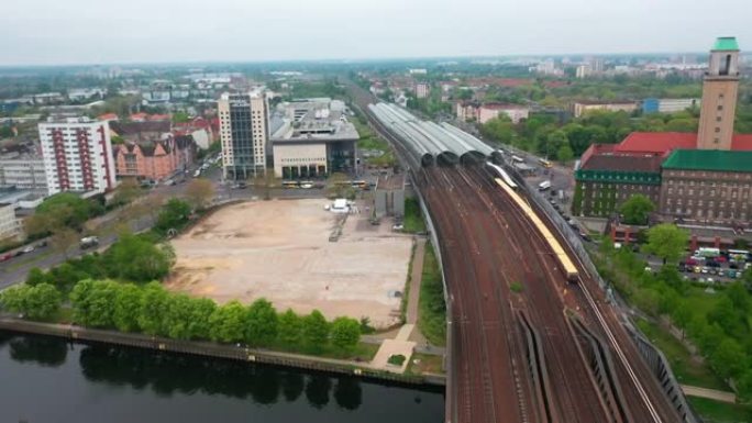 火车站鸟瞰图。印度铁路列车行驶在横跨哈维尔河的桥上的多轨铁路线上。住宅城市行政区的建筑物。柏林,德国