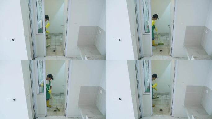 男性看门人用扫帚打扫房子内部
