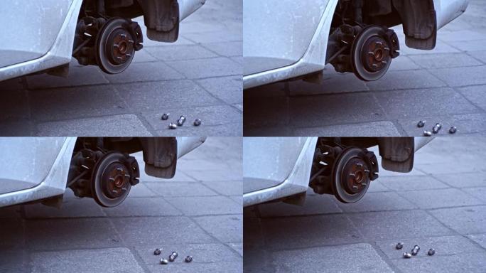 汽车轮毂，在车库车间轮胎更换过程中暴露出制动盘和制动片，凸耳螺母和扳手铺设在地面上