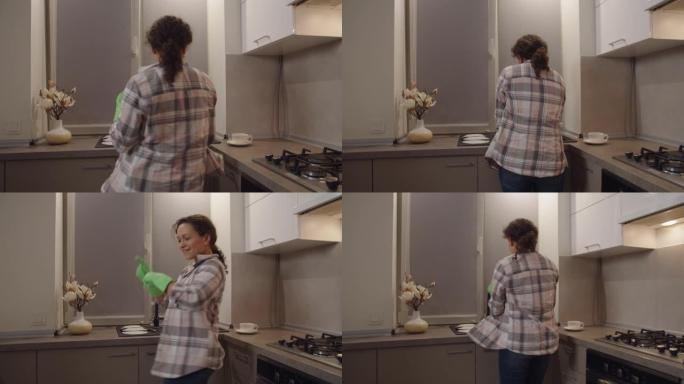 戴着手套的快乐成年女人在室内精神振奋地洗碗