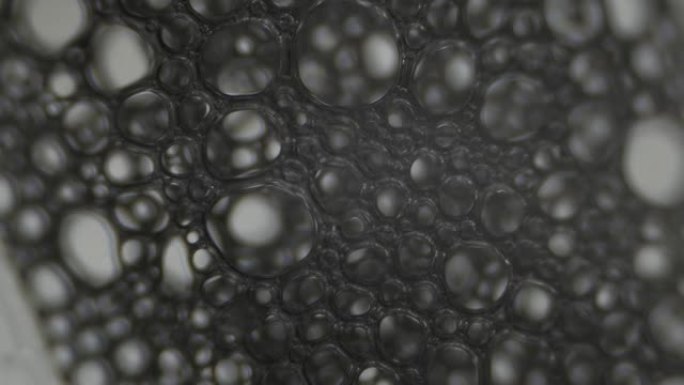 泡沫。显微镜下液体的表面张力。微观气泡破裂。浅景深。