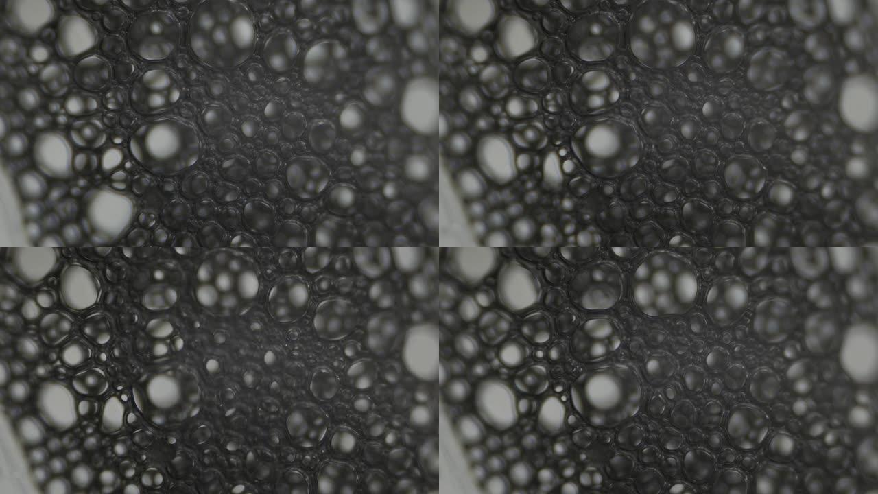 泡沫。显微镜下液体的表面张力。微观气泡破裂。浅景深。