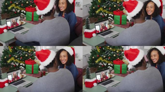 圣诞节时，与女性朋友在笔记本电脑上视频通话的快乐非裔美国夫妇