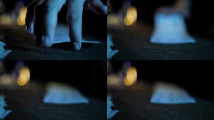 魔法师的手在黑暗背景高分辨率镜头中进行纸牌戏法的电影特写镜头。