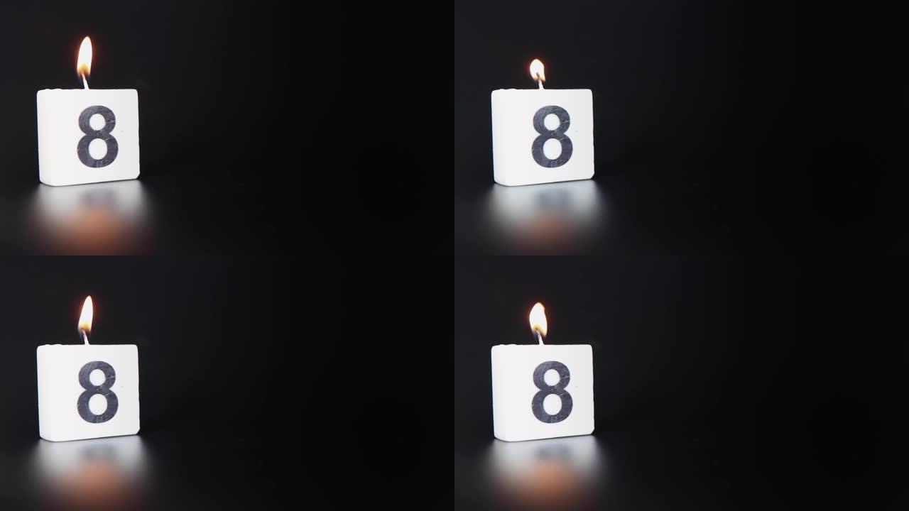 一根方形蜡烛，上面写着数字8被点燃并吹出，庆祝生日或周年纪念日。