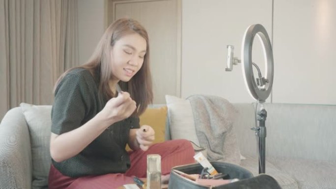 亚洲博主在家用化妆化妆品录制视频。病毒视频创意。