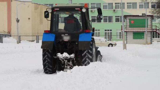 拖拉机在降雪，工业中清理冬季城市的雪山