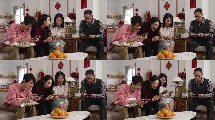 春节期间，全家人在客厅玩激动人心的手机游戏，亚洲妈妈问女儿如何玩。背面的中文文本翻译: 春天和祝贺